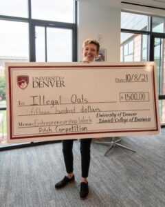 Clare Whetzel holding an oversized check awarding her $1,500