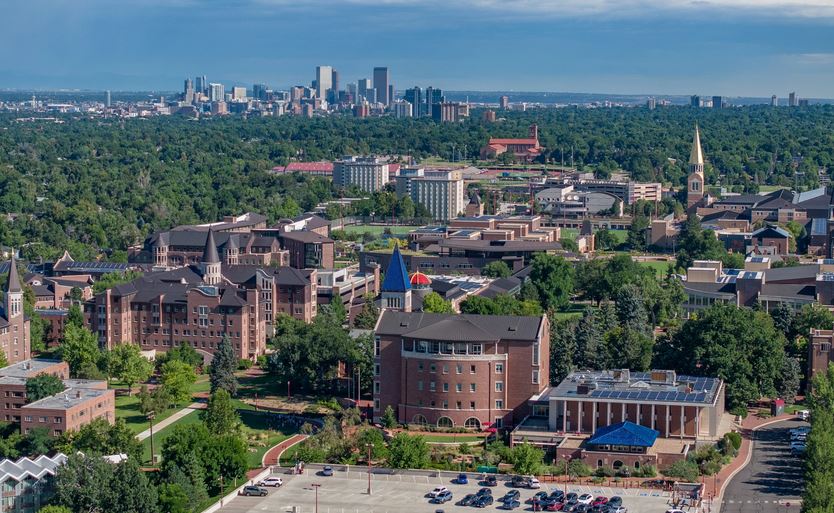 An aerial shot of the DU campus, with the downtown Denver skyline in the horizon