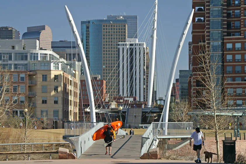 Man walking across a bridge in Denver's Confluence Park