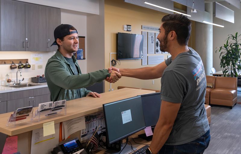 Two people shaking hands across the counter at the Veterans Affairs office
