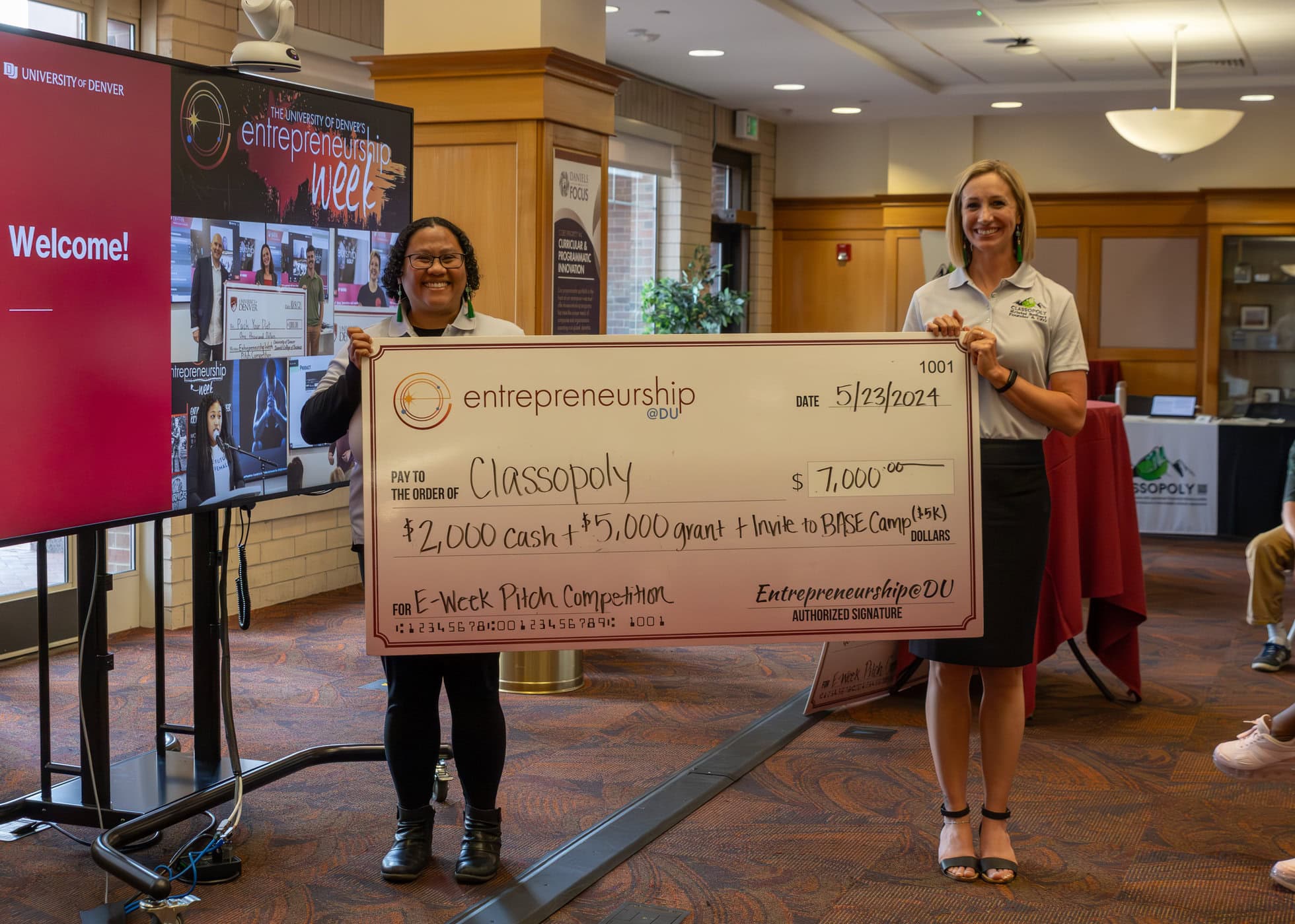Team Classopoly, winners of the pitch competition hold a giant check with the price of $2,000 cash, $5,000 grant and an invite to BASE Camp