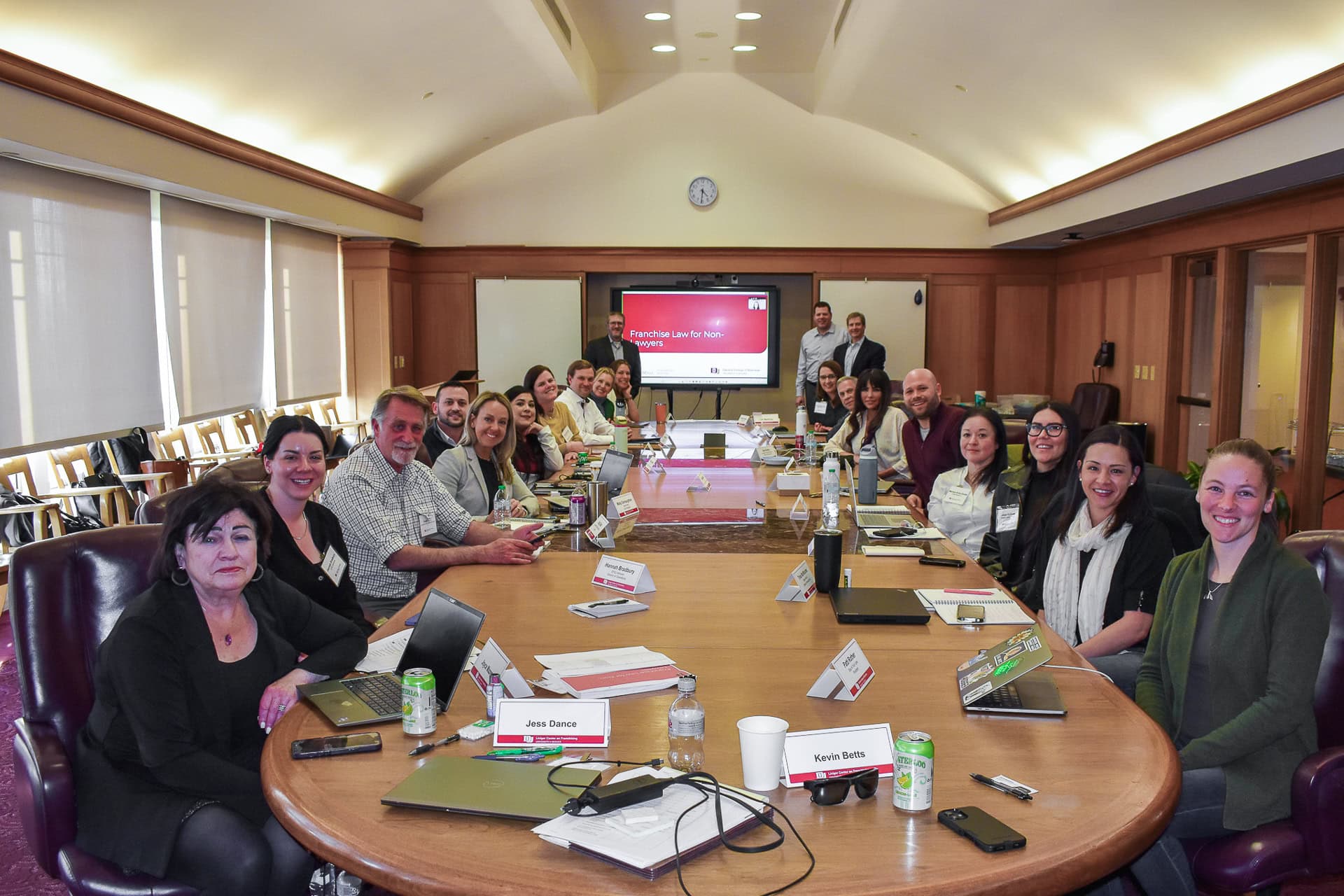 A group of executives at a boardroom table posing for a photo.