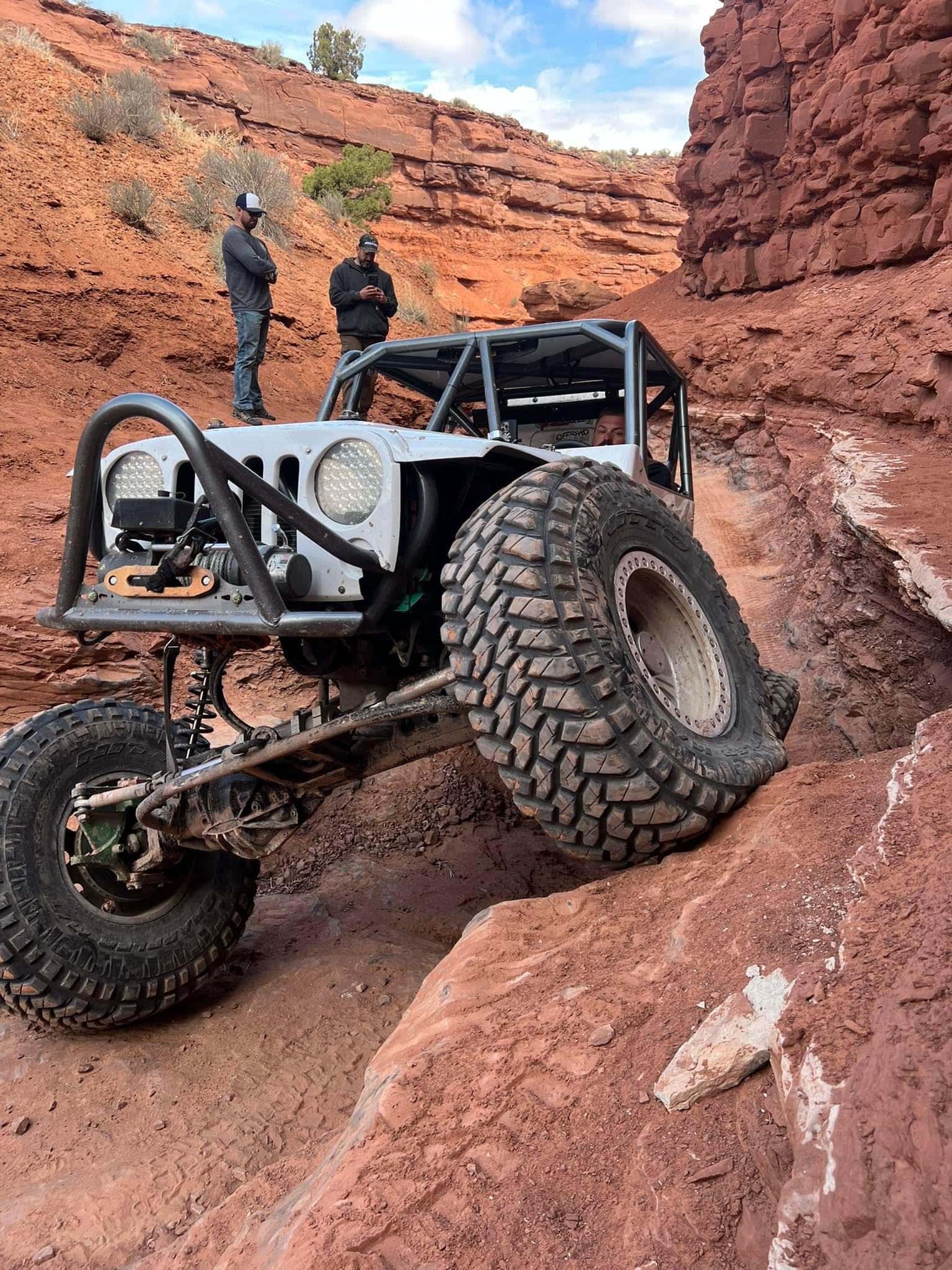 Marc Bastnagel standing behind his crawling vehicle, propped on red rocks