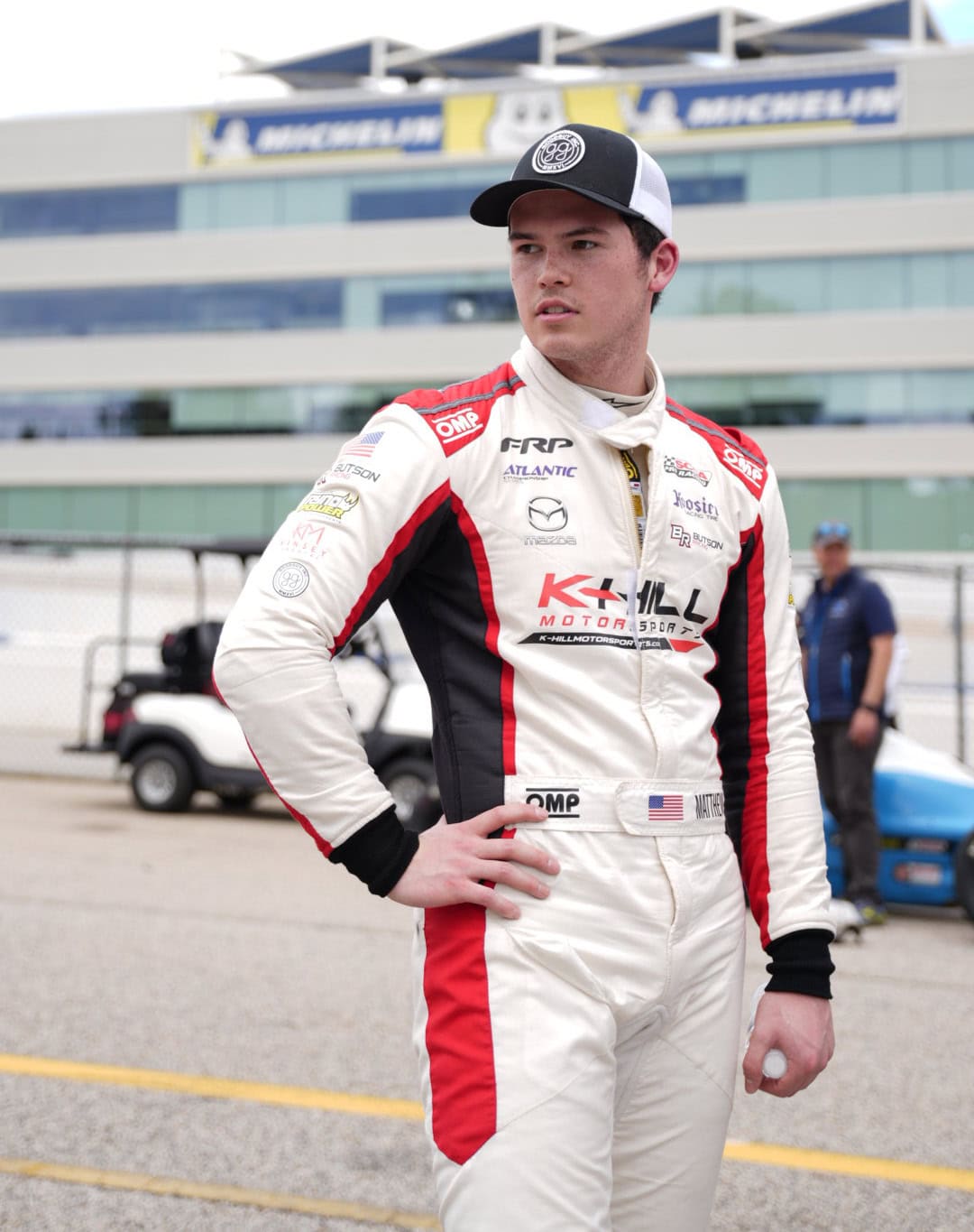 Matthew Butson posed on a racetrack in race gear