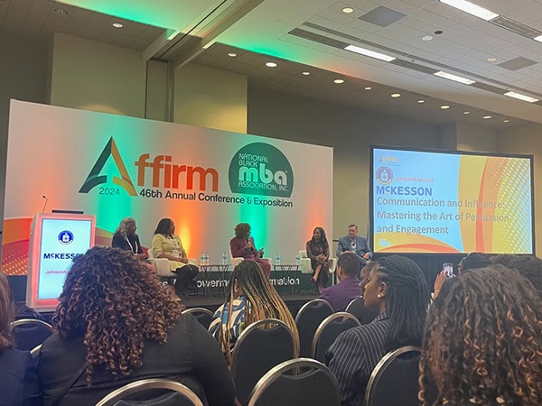 An audience of Black professionals at a panel discussion at a recent conference