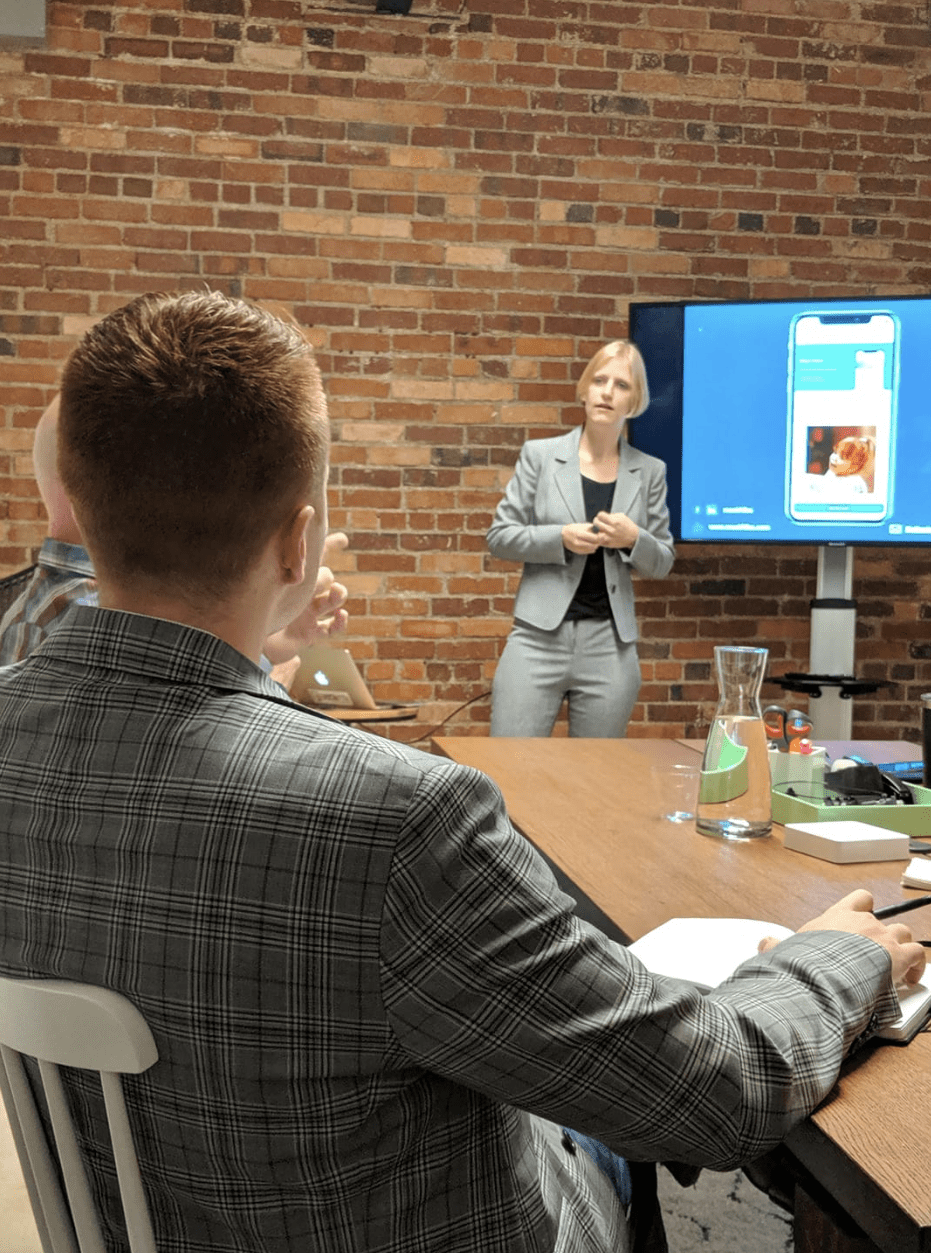 An entrepreneur pitches their startup to investors in front of a monitor