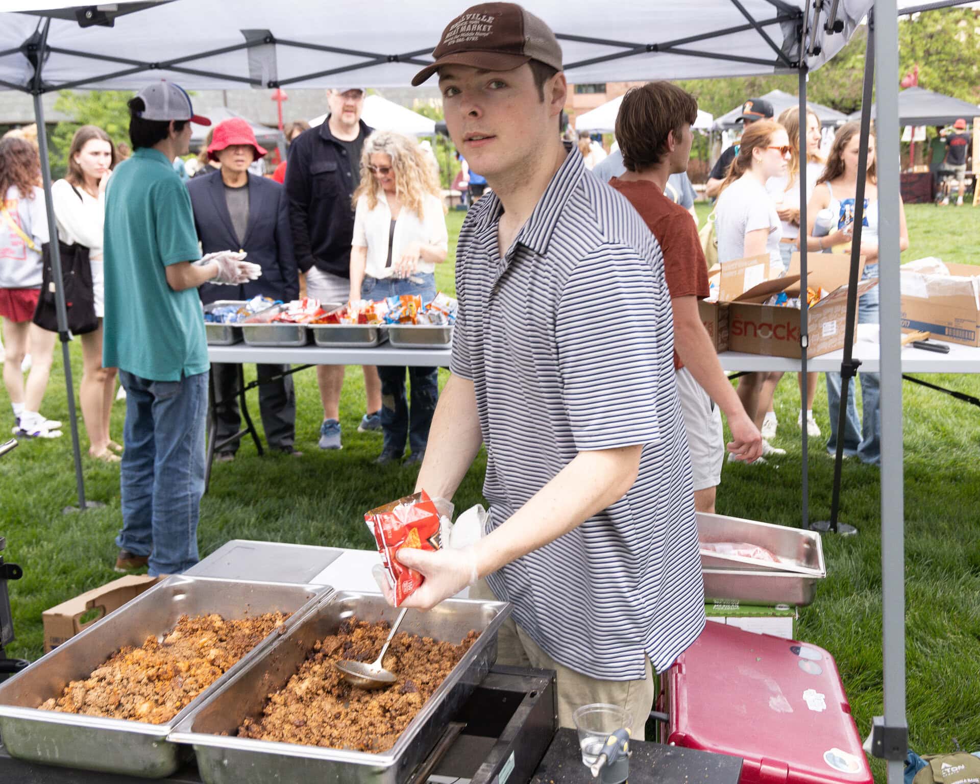 A student serving brisket from a food tray