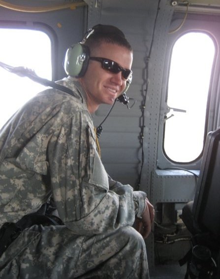 Steve Delt in Army fatigues with a headset inside an airplane