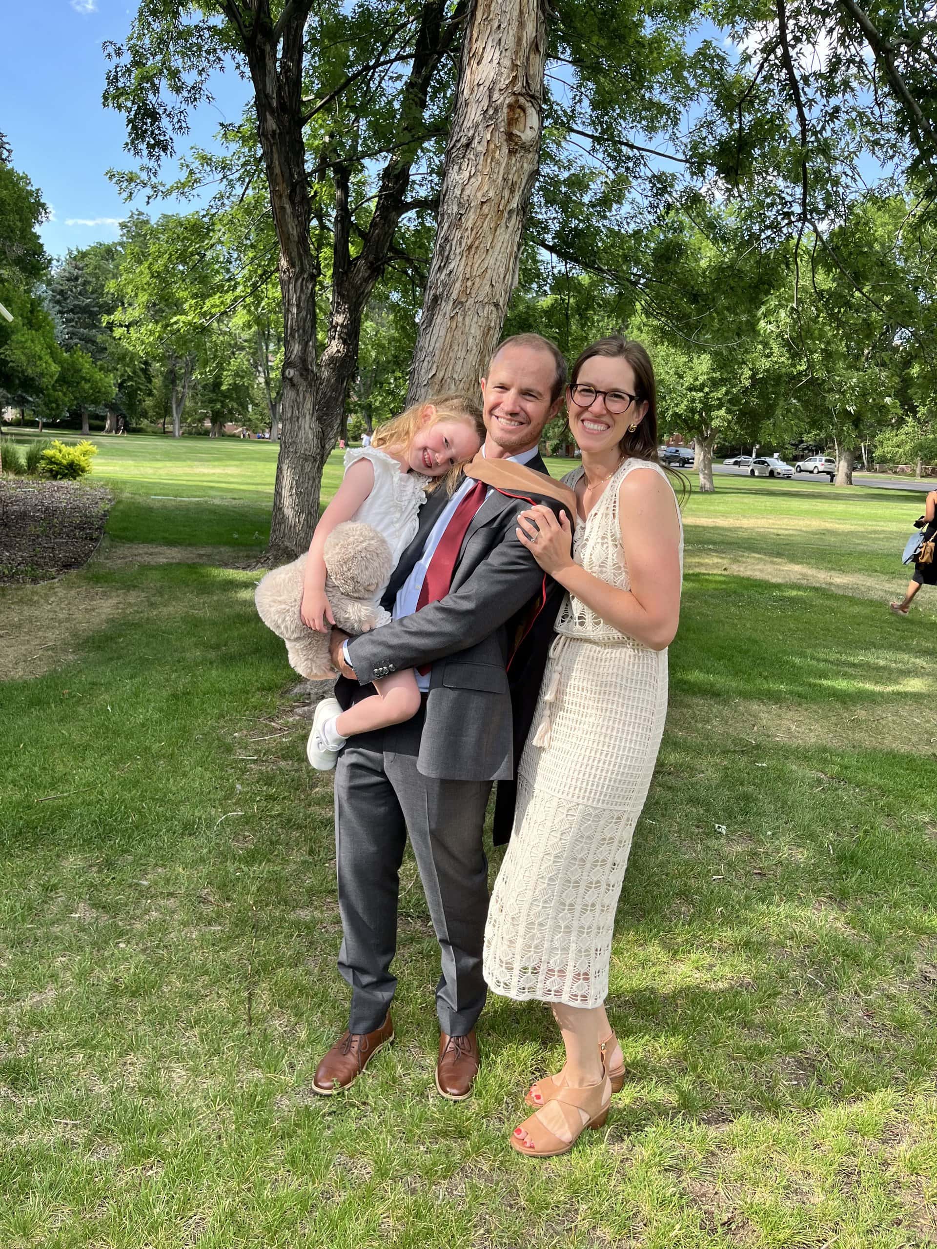 Steve Delp holding his daughter and posing with his wife on graduation day