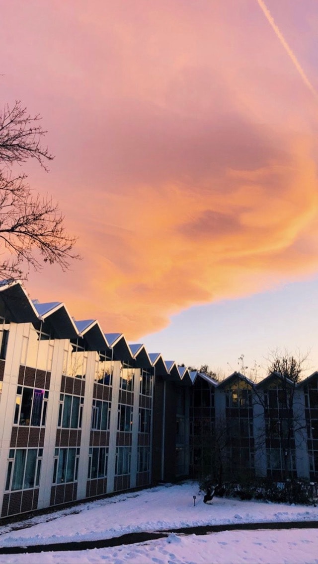 Purple and orange clouds over a DU dorm building