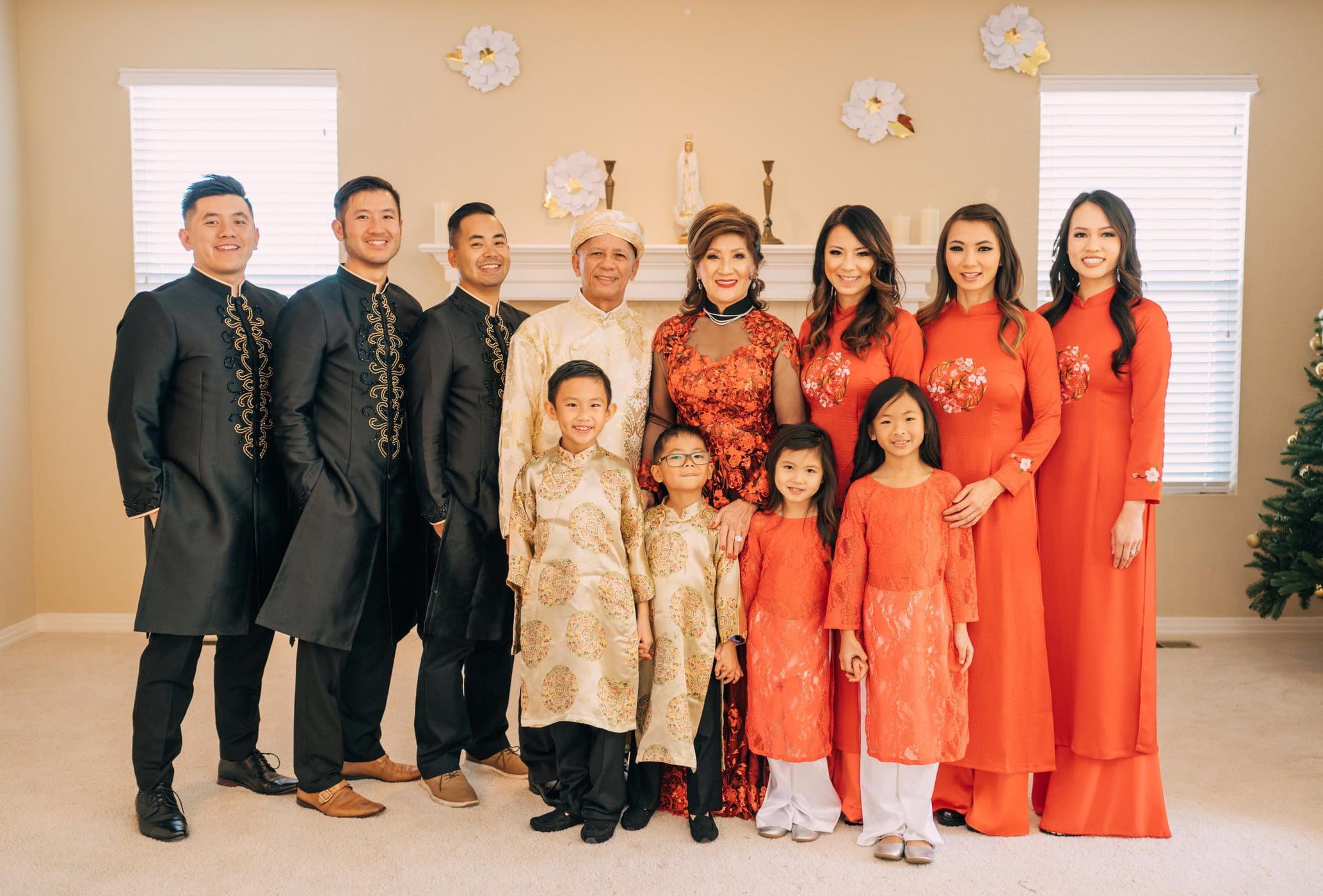 A family stands together, men on one side, women on the other, wearing traditional Vietnamese outfits.