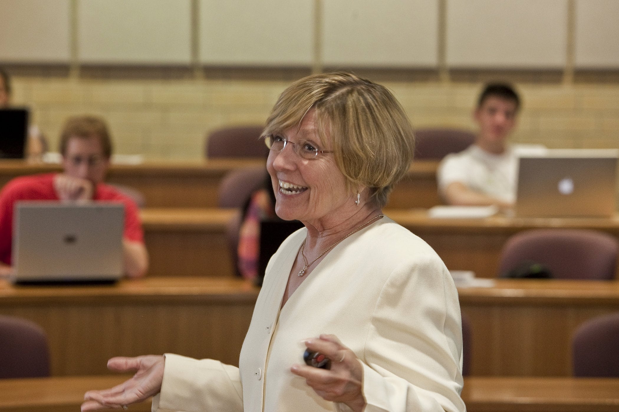 Carol Johnson holds her hands out as she lectures in a classroom