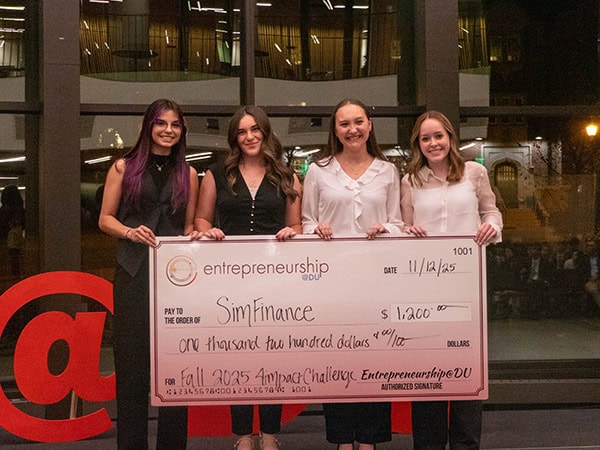 Student entrepreneurs standing with a second-place check