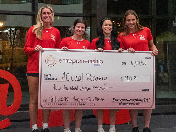 Student entrepreneurs holding a third-place check.
