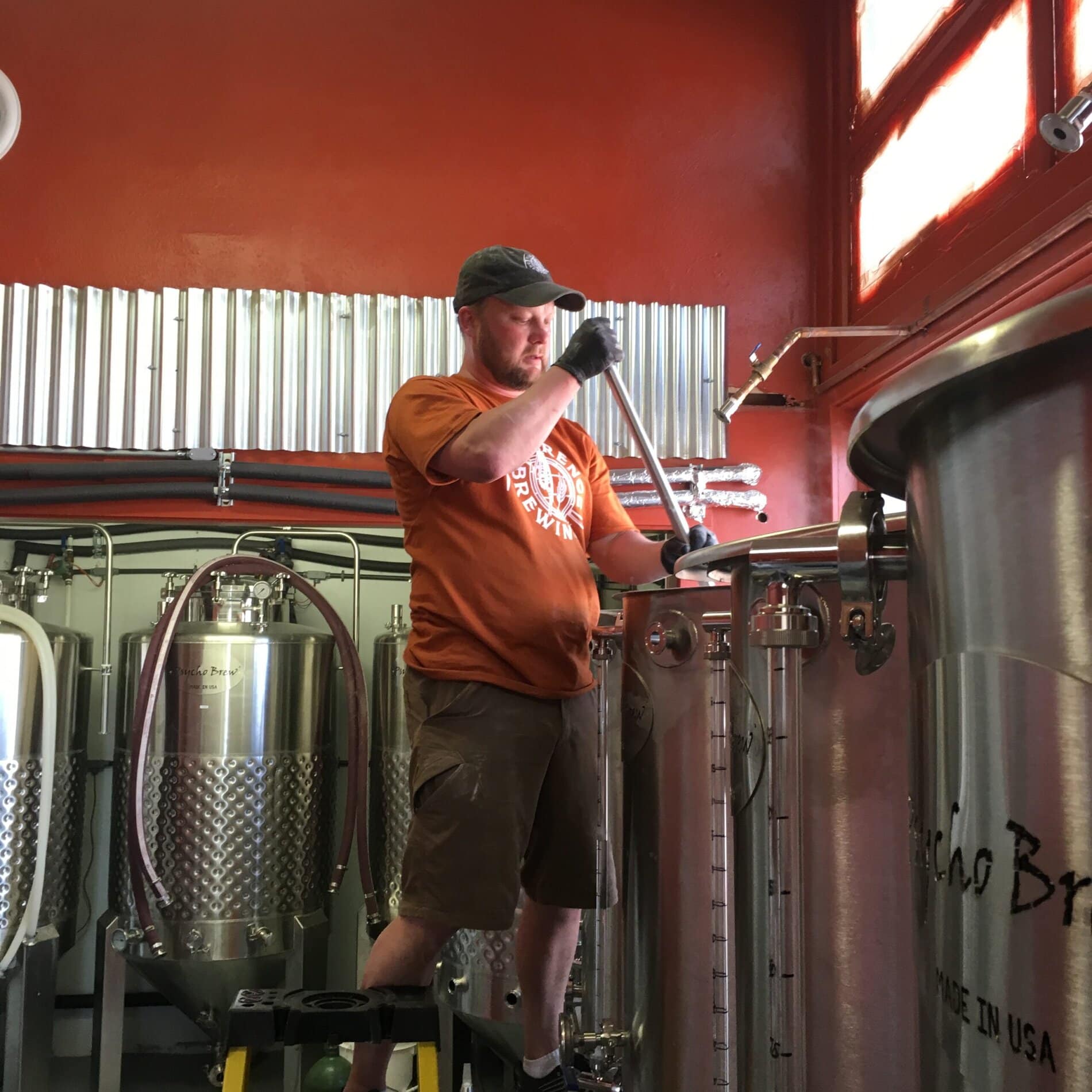 Hans Prahl stirring hops in a mash ton.