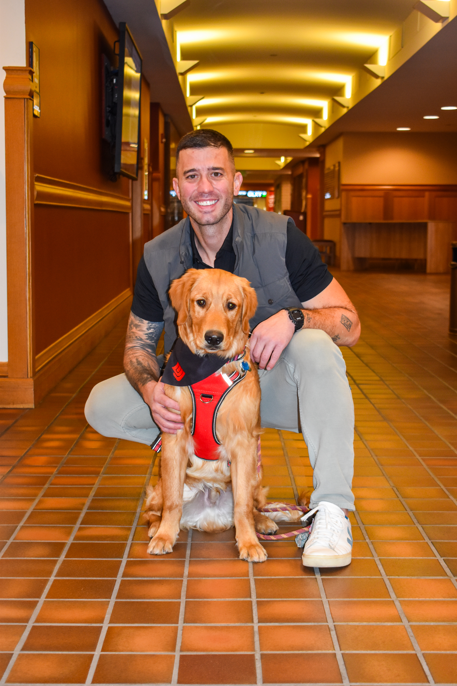 Geoff and his therapy dog in training in a Daniels hallway