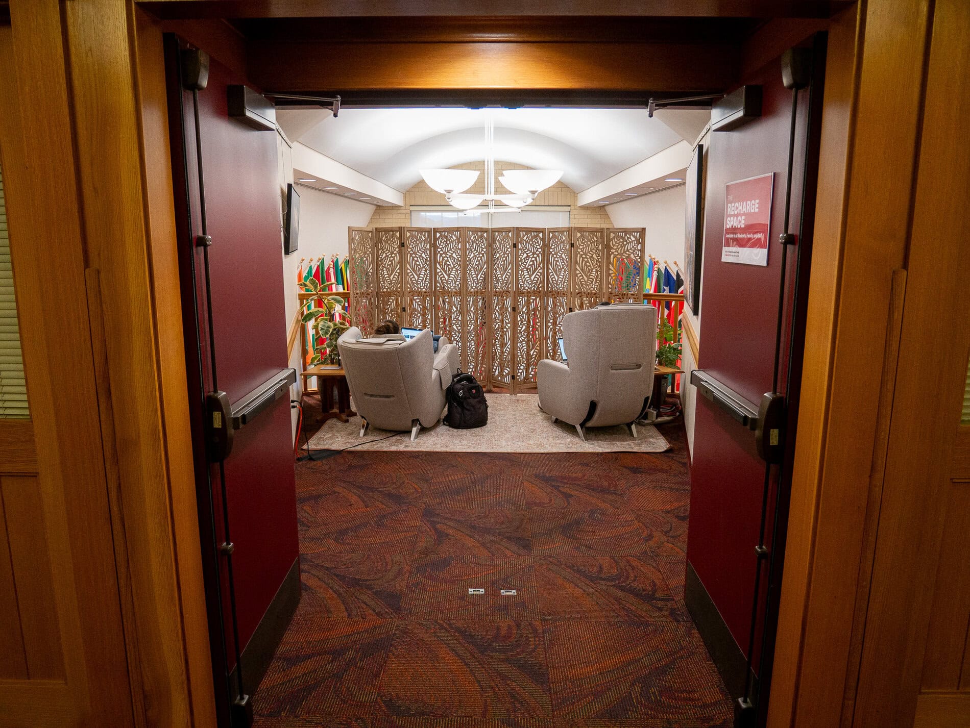 Two massage chairs behind a folding screen in the Daniels building hallway