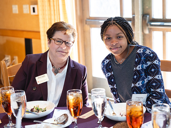 Sharon Lassar and a student at a table with food and drink