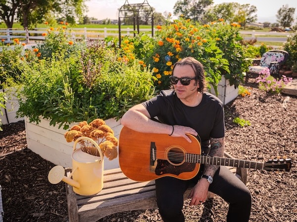 Man with a guitar sitting outdoors