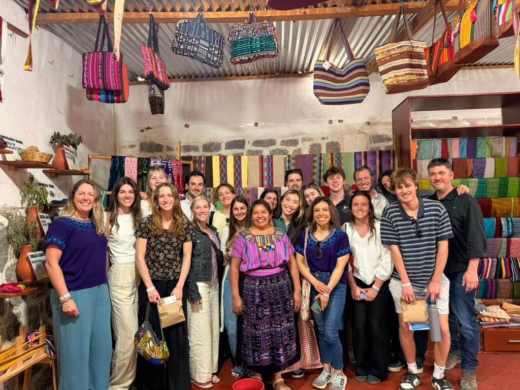 Students in a colorful Guatemalan textile shop
