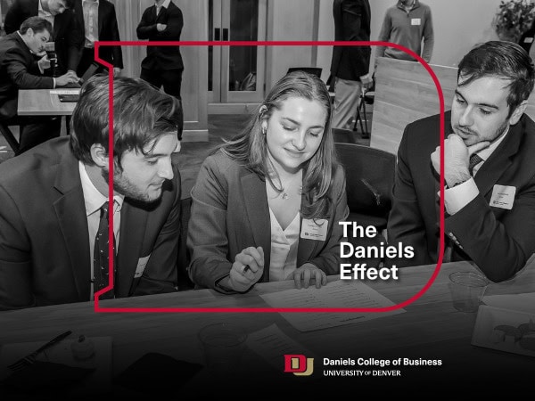 Three students looking at a case competition on the table