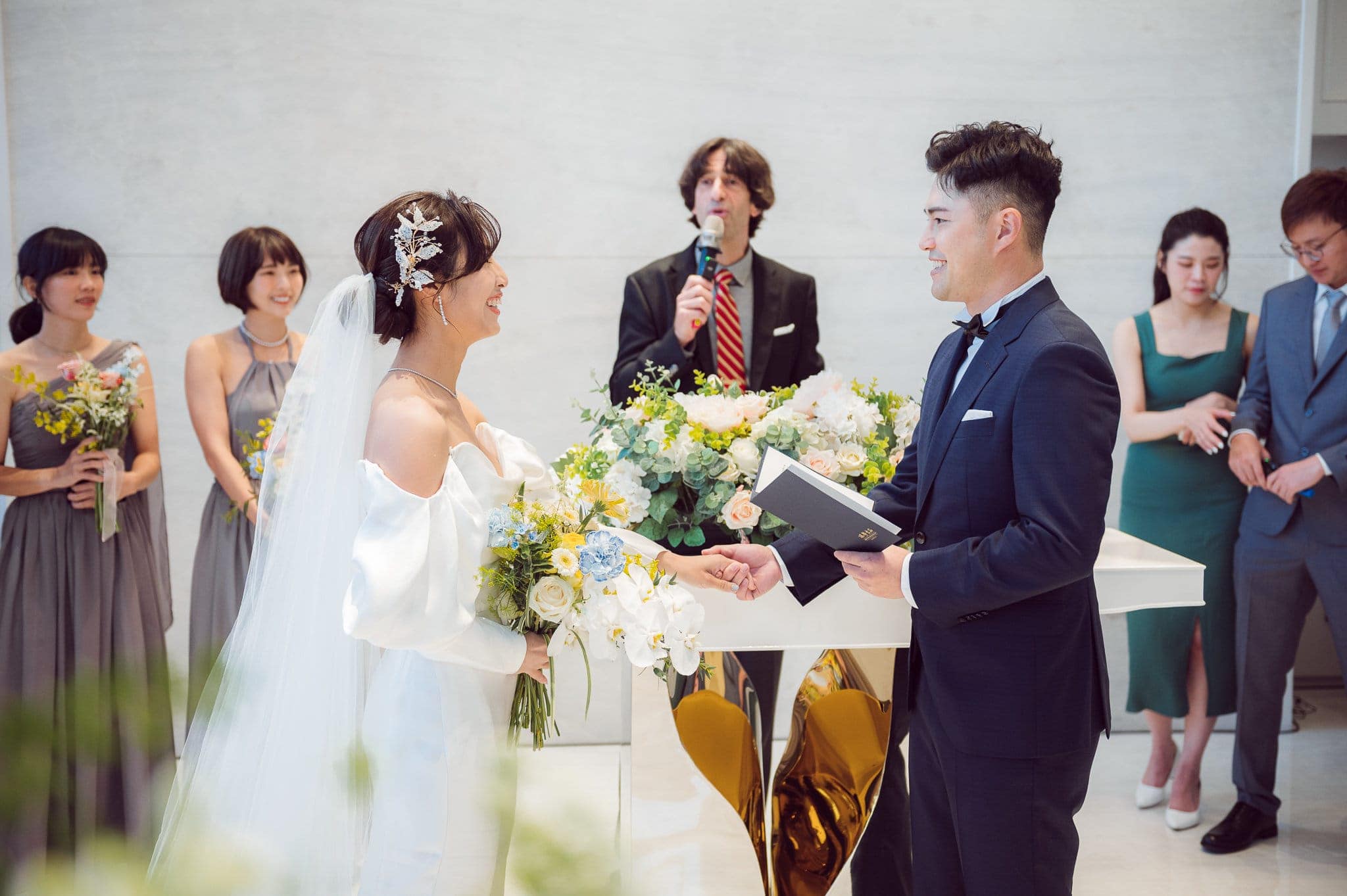 Phil Beaver, with a microphone, leads a wedding ceremony for the bride and groom
