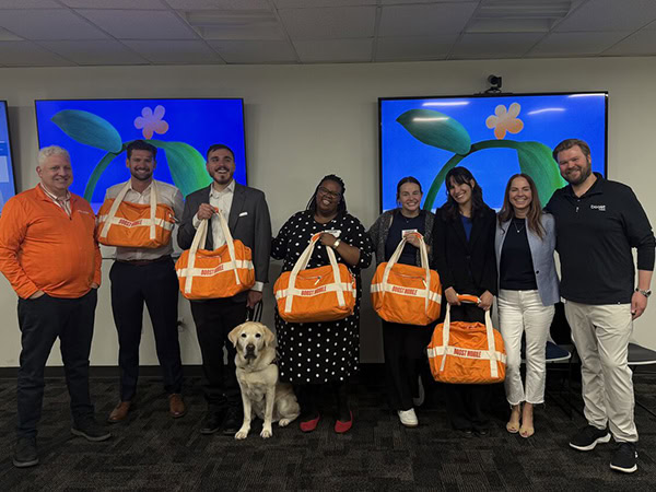 Students at Boost Mobile headquarters holding tote bags