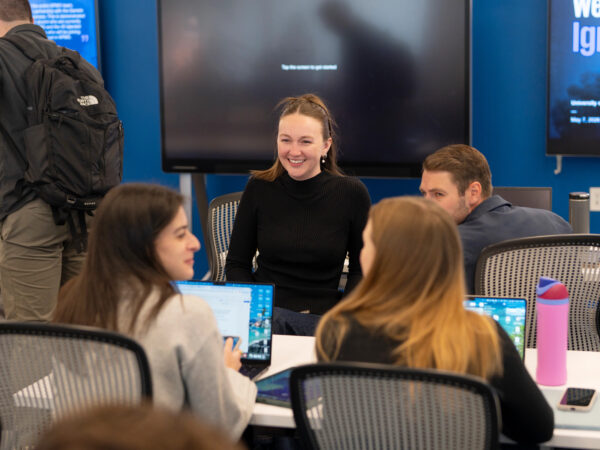 Four students around a table at KPMG headquarters.